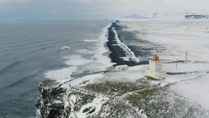 雷尼斯法贾拉海滩和迪霍莱灯塔周围标志性黑沙滩的空中无人机视图。冰岛美丽的南部冬天靠近维克。无法识别的