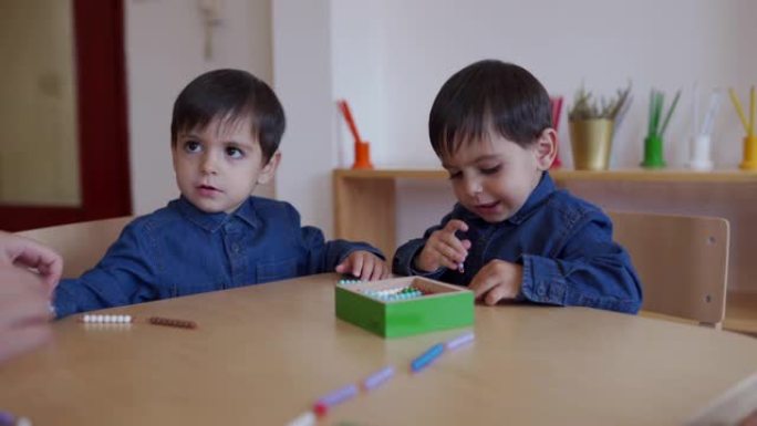 双胞胎男孩一起在学龄前教室玩耍