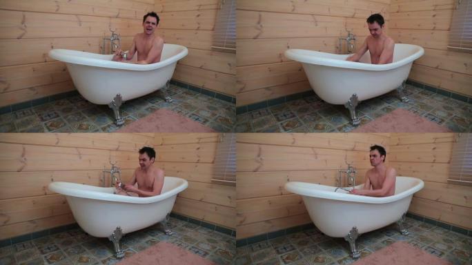 一个男人坐在浴室里设定水温，唱着歌。