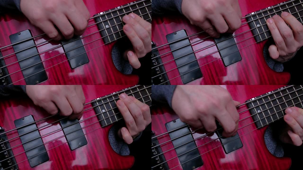 演奏红色电贝司吉他的男人的手指特写