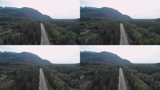 华盛顿州金条附近山区之间森林中繁忙的2号高速公路的鸟瞰图。无人机视频与前向摄像机运动。