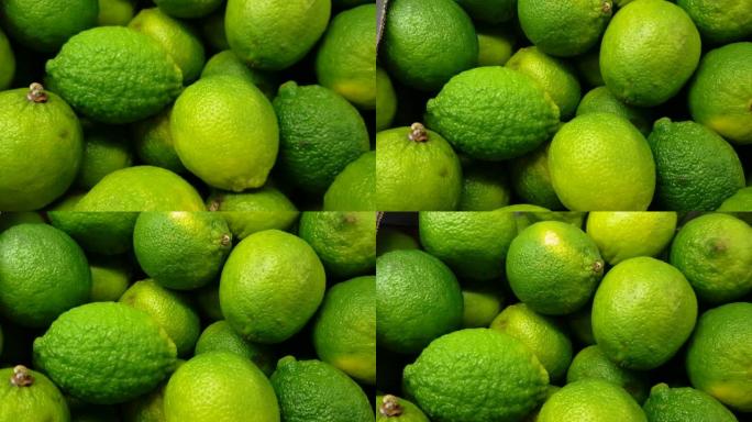 绿色蔬菜柜台上明亮的整个绿色酸橙的特写镜头，4k视频，慢动作，有机水果背景。