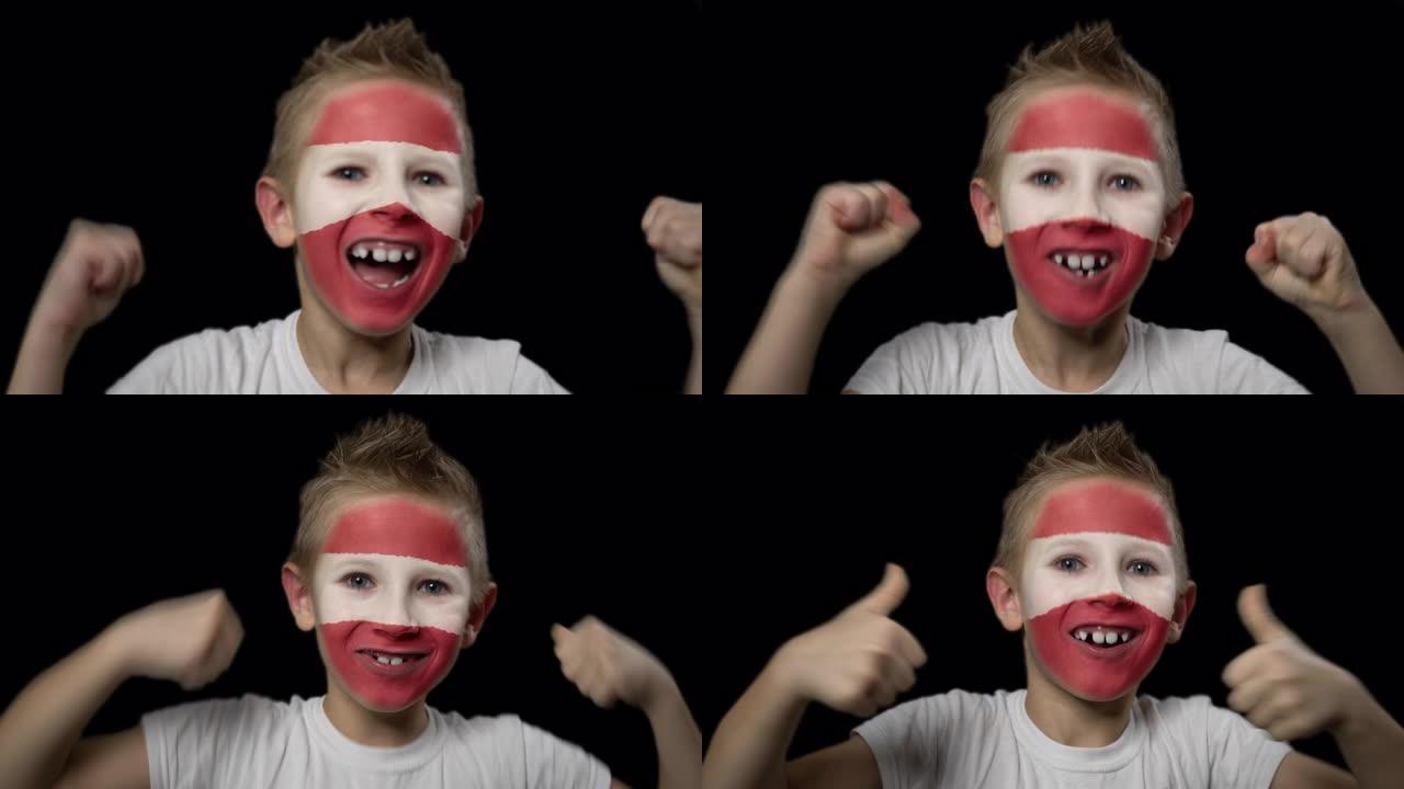 快乐的男孩为他最喜欢的拉脱维亚队的胜利而高兴。脸上涂着民族色彩的孩子。