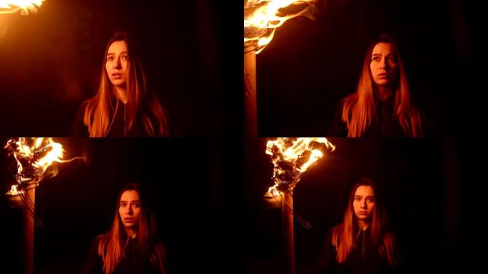年轻女子手持火把站在黑暗的森林中