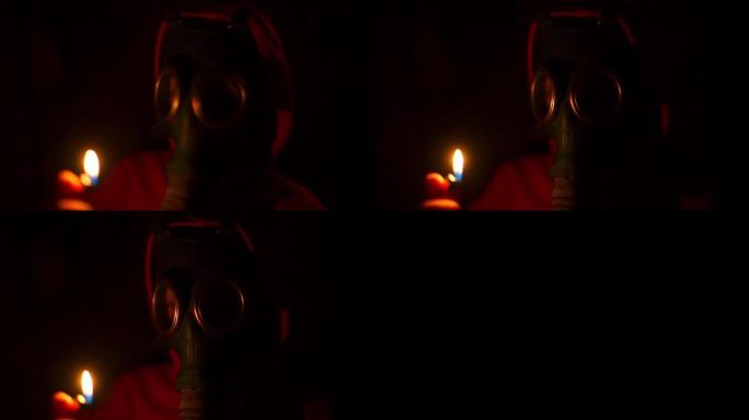戴着防毒面具的救生员在黑暗中手里拿着一个燃烧的打火机。