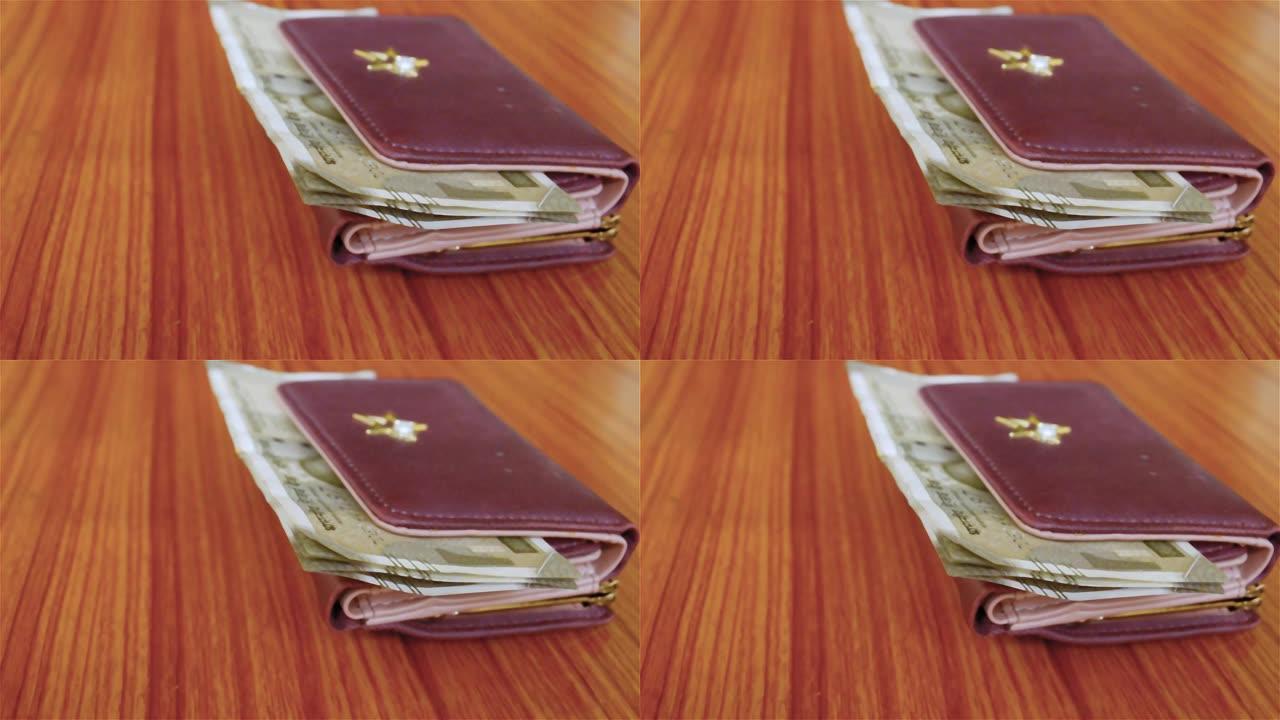 印度500卢比纸币棕色钱包皮革钱包在木桌上。