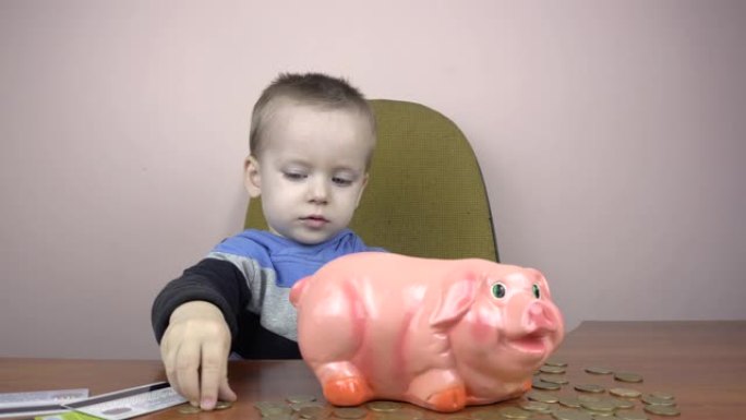 快乐男孩孩子把硬币扔进小猪存钱罐。省钱概念。