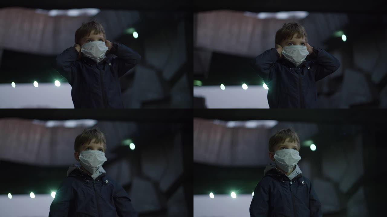戴着医用防护面具的男孩在冠状病毒新型冠状病毒肺炎大流行期间站在避难所里，周围有害怕的手表。由于室外红
