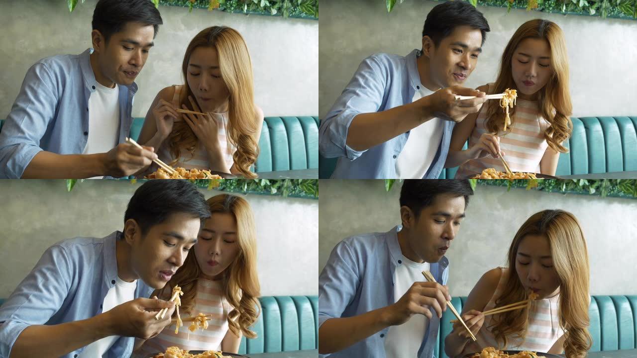 年轻夫妇吃泰式炒河粉。