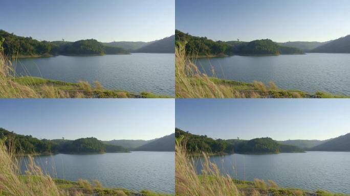 从湖上有绿色海岸和山丘的山丘或水坝上的景色