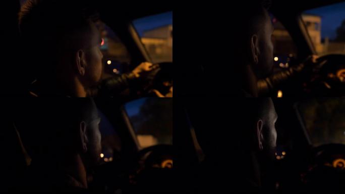 年轻人的特写镜头握着方向盘，晚上开着一辆现代汽车。男司机在空旷的道路上开着他的SUV汽车。晚上，男子