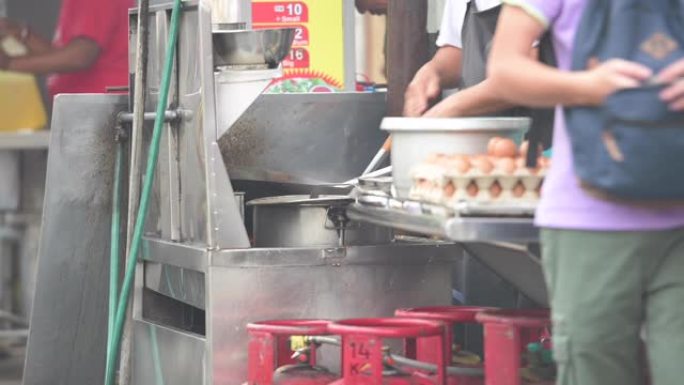 一名男子正在马来西亚吉隆坡街头的摊位上煮炒面。