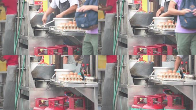 一名男子正在马来西亚吉隆坡街头的摊位上煮炒面。