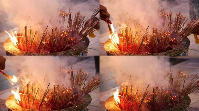 传统的火焰点燃香烛祈祷在佛教寺庙火焰烛光燃烧温暖的光与烟香烛。