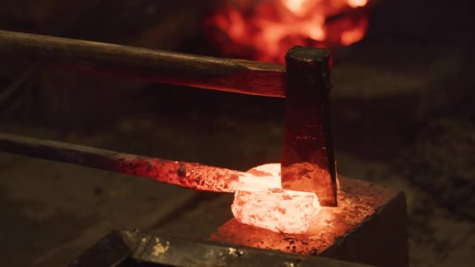 斧头铜被剑史密斯大师击中发光的红色热锭折叠钢。背景中的传统日本锻造。日本工艺文化。