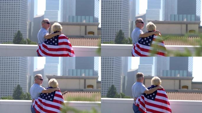 洛杉矶屋顶上带着美国国旗的高级夫妇4k慢动作60fps
