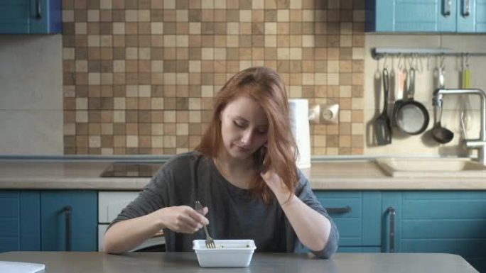 女孩在厨房吃方便面，打电话。美味的亚洲食物