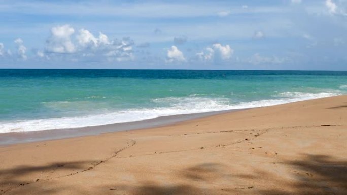 慢动作热带海滩白色沙滩和蓝色大海的夏季晴天。海洋宁静的海滩风景泡沫波在海滩上，有蓝色的海洋沙滩。海滨