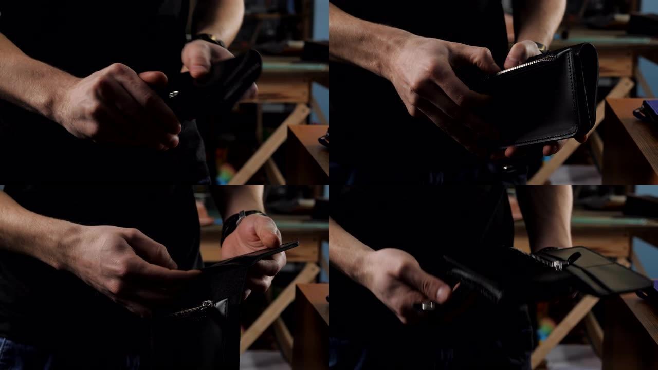 一名男子展示了一个钱包是在制革商的车间里手工制作的，特写镜头。