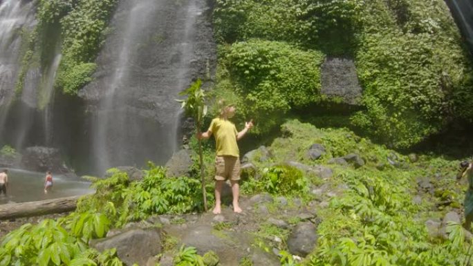 一个快乐的孩子游客参观巴厘岛美丽的斐济瀑布。巴厘岛旅游概念