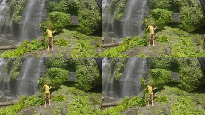 一个快乐的孩子游客参观巴厘岛美丽的斐济瀑布。巴厘岛旅游概念