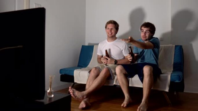 两个男朋友坐在沙发上看电视体育比赛时未能打开啤酒瓶
