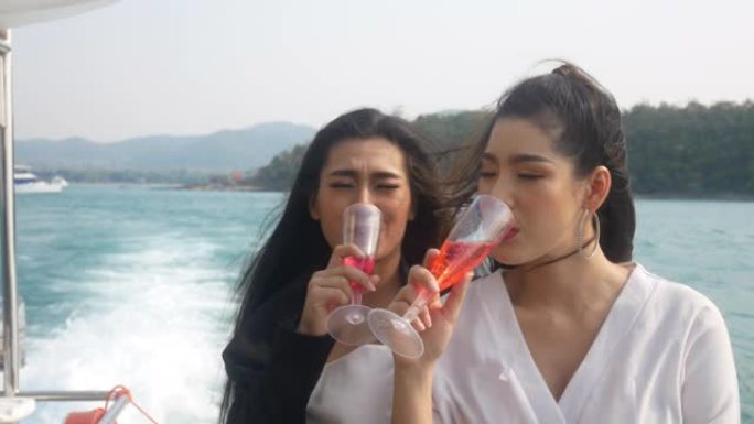 美丽的亚洲年轻女子在泰国的快艇上旅行和喝酒。