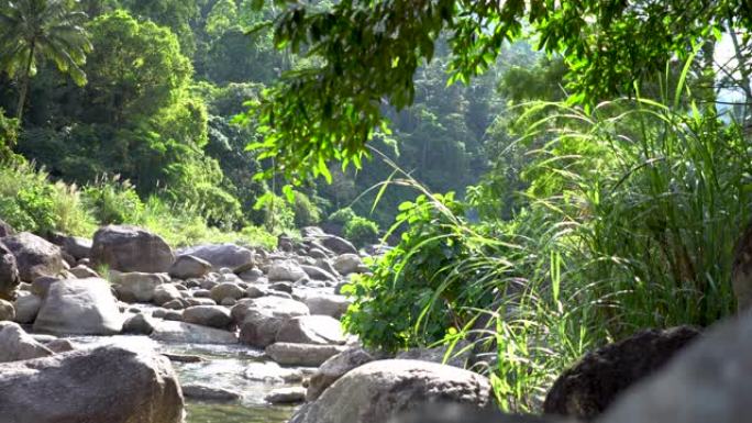 自然水流从山上经过许多岩石到乡村小村庄的河流。瀑布声降下来放松平静与和平。