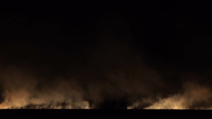铁路附近的田野发生火灾和烟雾灾害。火车穿越火堆。延时。