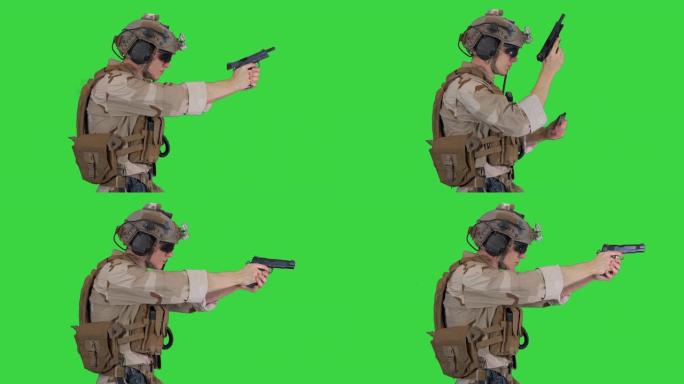 一名头上戴着头盔的特种部队士兵在绿屏上用手枪射击