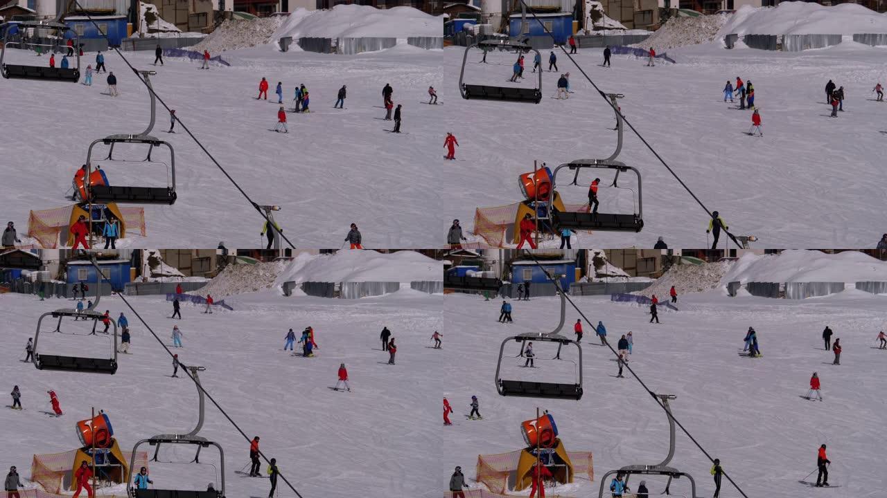 滑雪者和滑雪者在滑雪胜地的雪坡上骑行