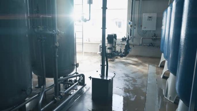 日光照射下水厂生产的工业内部。用于过滤和饮用水处理的大型钢罐。行业背景