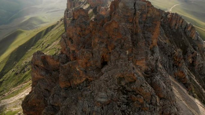 日落时无人机飞越尖锐的岩石露头的鸟瞰图。用于极端登山的陡峭的岩层山。飞行穿越旅行视频