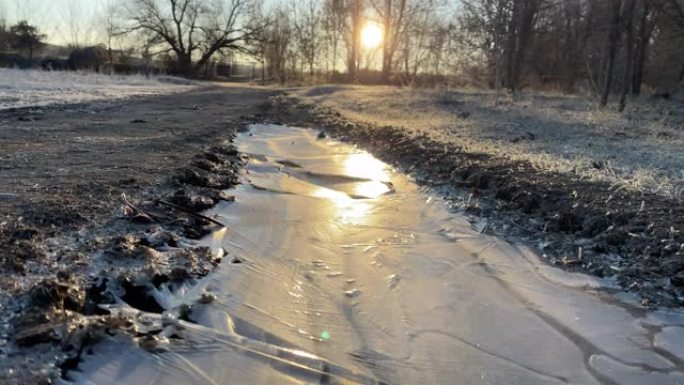 秋天的霜冻，冰冻的道路覆盖着冰，黎明时草地上的白霜。
