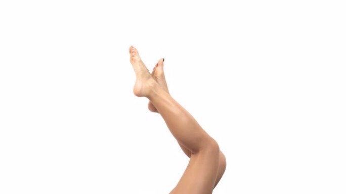 侧视图苗条女性的腿赤裸和赤脚轻轻移动。苗条和健康的身体概念。孤立，在白色背景上
