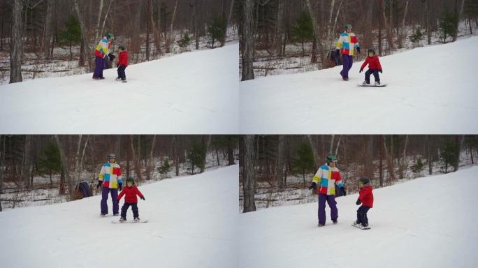 年轻人滑雪板教练tiches小男孩如何骑滑雪板。冬季活动概念。慢动作镜头