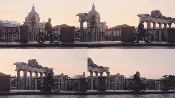 年轻人游客背着背包和自行车在日出时在罗马广场散步。从全景的角度来看，意大利罗马的历史帝国罗马罗马。