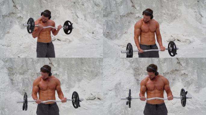 集中肌肉发达的人在山上用沉重的杠铃锻炼。