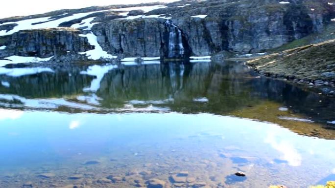 许多蚊子在雪路Aurlandsvegen附近的山湖上空飞行。挪威。