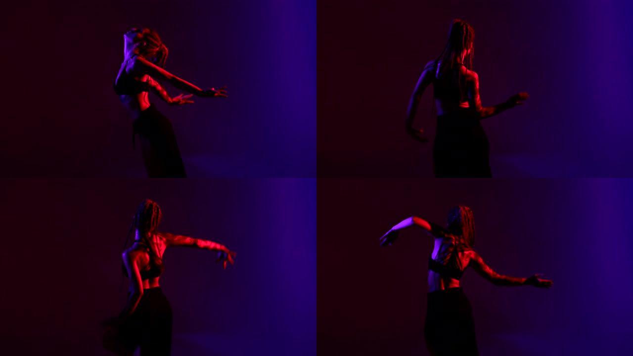 黑色打扮和辫子的女人东方在蓝色和红色的背景上跳舞。