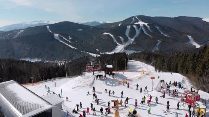 鸟瞰图滑雪者在滑雪缆车附近的山顶滑雪场上滑雪。滑雪胜地