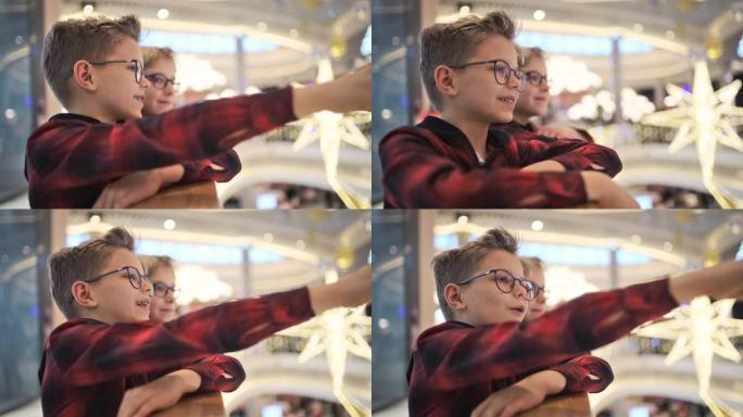 两个小男孩在购物中心看圣诞装饰品