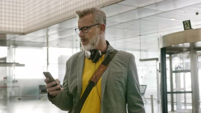 在机场使用智能手机的大胡子商人