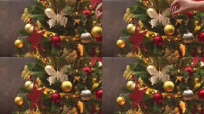 手把金色装饰品放在圣诞树上 -- 停止运动