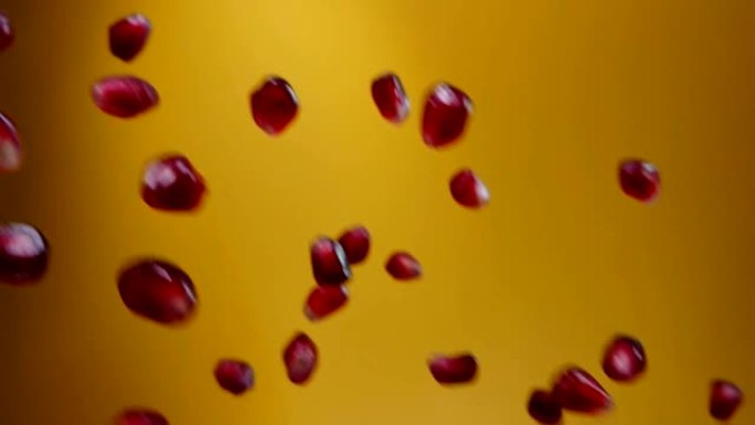 石榴颗粒的特写在黄色背景上斜向下降