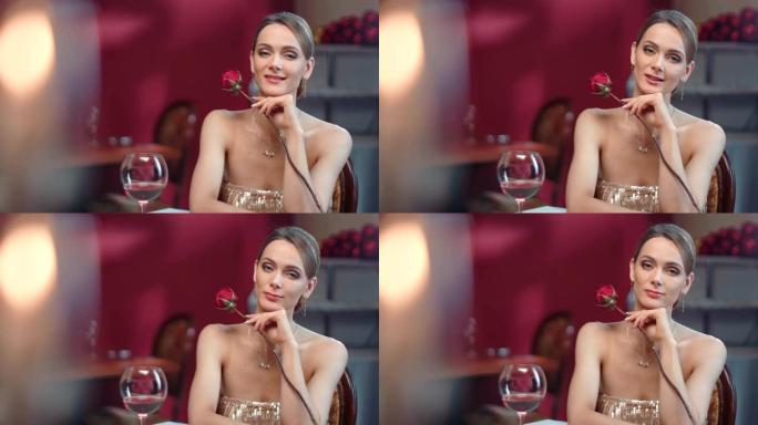 浪漫的女人在豪华餐厅与玫瑰和bocal葡萄酒合影。在4k红色相机上近距离拍摄