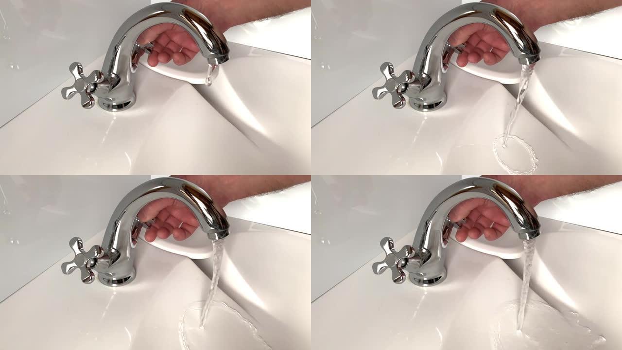男人的慢动作打开镀铬水龙头和洗手盆中的水流
