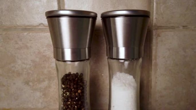 盐和胡椒研磨机并排缓慢地向下平移，接近现代简单的设计。