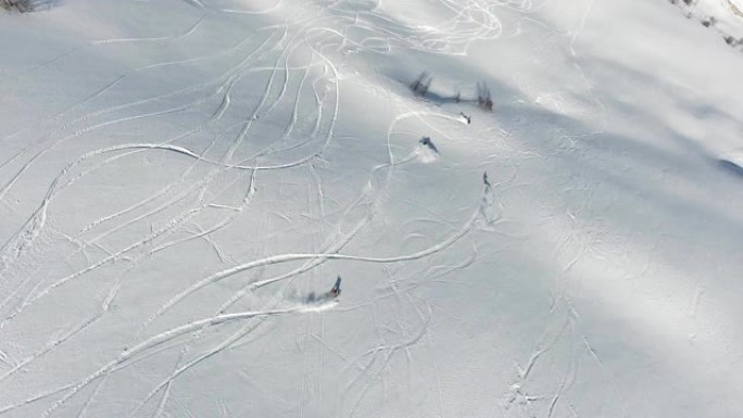 在阳光明媚的冬日里，一群极端的滑雪者在高山顶上，积雪清新。滑雪道斜坡上的自由行。俯视图。佐治亚州高加