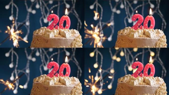 生日蛋糕，蓝色背景上有20个粉色蜡烛和烟火。慢动作和特写视图